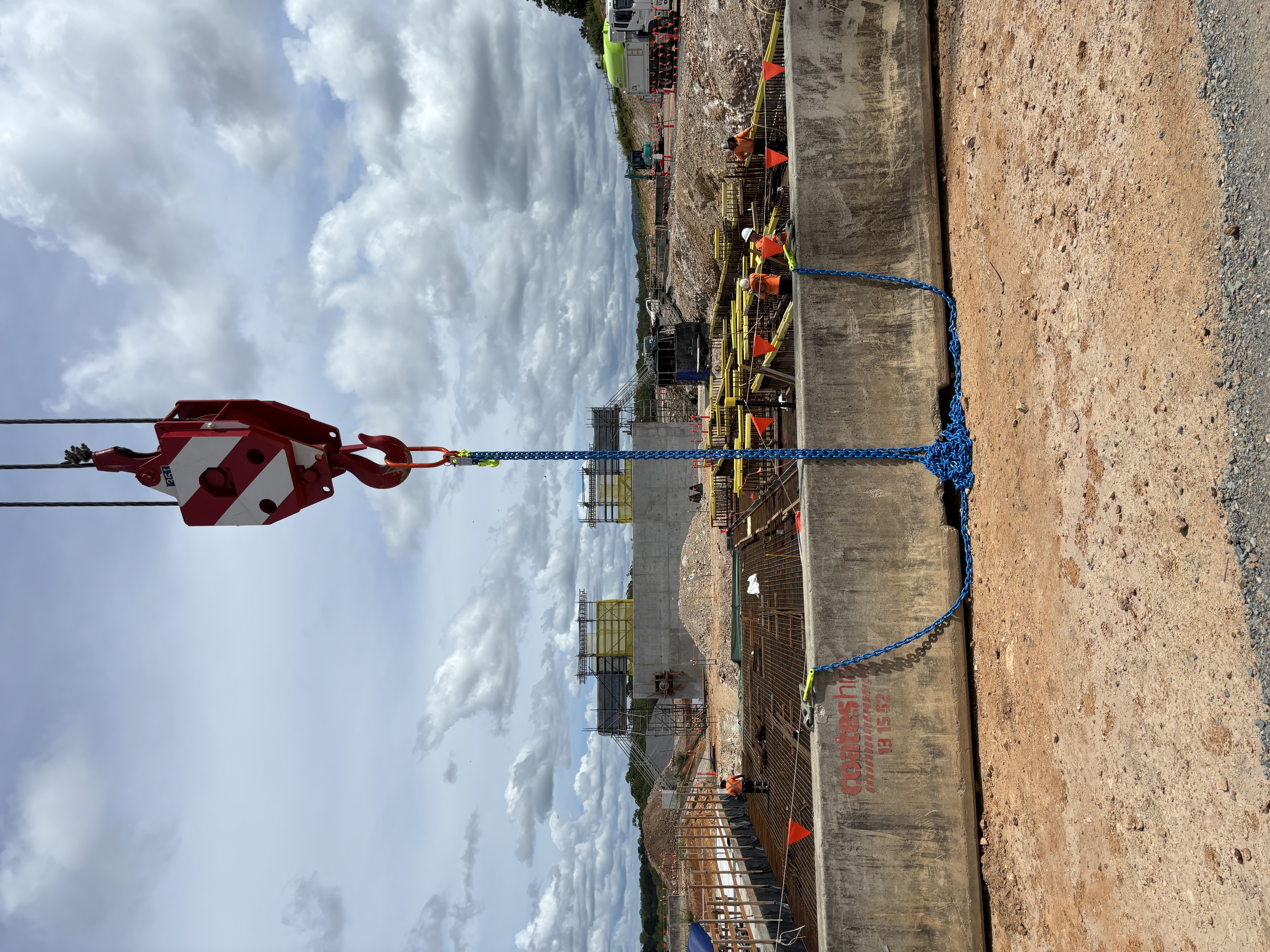 Field photo of a crane hook block above an active construction site